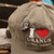 Rex Uranus riding a rocket hat pin attached to a green I Love Uranus hat from Uranus Fudge Factory.