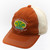Burnt orange Uranus Gas ’N Lube trucker hat with cream mesh back, embroidered logo patch, and humorous slogan “We Pump it in the Front & Lube it in the Rear.” Angled side view.