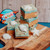 Life's a Beach Fudge displayed on a wooden cutting board with seashell candies. 