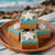 Salted caramel coconut fudge topped with candy starfish and seashells on a round wooden plate by the ocean