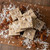 Top view of sliced German chocolate cake fudge arranged on a wooden board with scattered pecans and shredded coconut.
