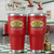 Red Uranus Gas N Lube insulated tumbler with retro gas station design displayed in vintage service station setting with pumps and tools.