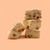 A pound of Peach Cobbler Fudge in a stack of 3 with a fourth square leaning against it. The background is peach. 