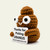 Light brown crocheted Emotional Support Poop holding a Thanks for Picking Uranus sign, three-quarter angle
