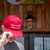 Man tipping the brim of his red MUGA hat outside the Uranus Fudge Factory & General Store.