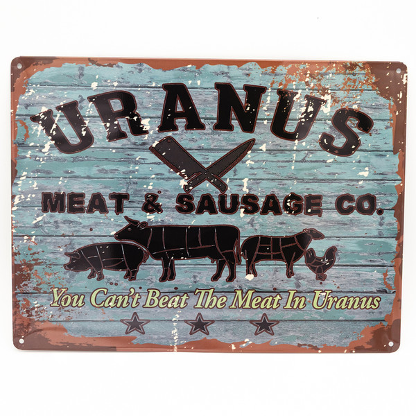 A distressed metal souvenir sign for Uranus Meat & Sausage Co. featuring butcher cut animal illustrations and a humorous slogan