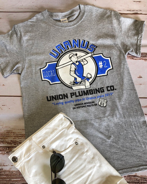 Gray Uranus Plumbing Co novelty t-shirt laid flat from Uranus Fudge Factory