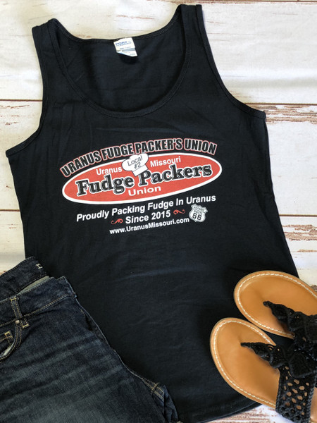 A flat lay photo of the black Uranus Fudge Packer tank top paired with jean shorts and sandals
