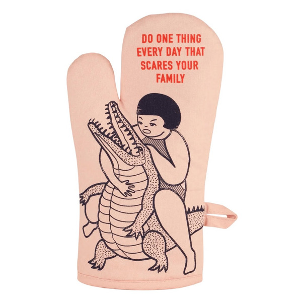 Pink oven mitt featuring a woman wrestling an alligator with do one thing every day that scares your family text.