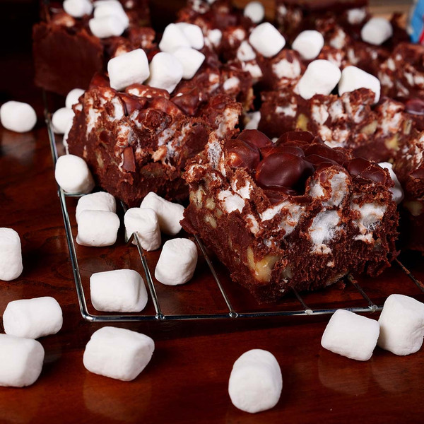 Freshly cut Rocky Road Fudge from Uranus, loaded with nuts and marshmallows, cooling on a wire rack.