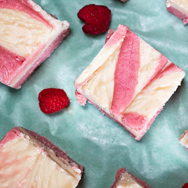 Pink and white swirled raspberry fudge squares on green paper from Uranus Fudge Factory.