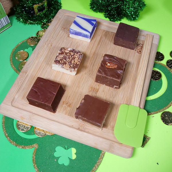 Taste of Uranus sampler pack with six fudge flavors on a cutting board with St. Patrick's Day decor