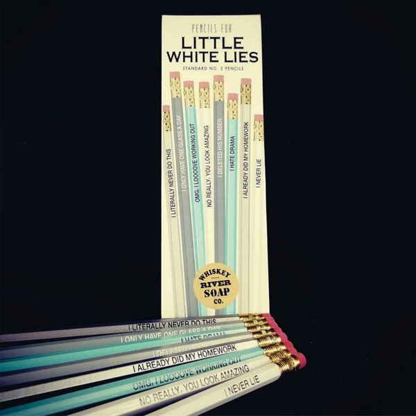 Packaged set of grey and blue Pencils for Little White Lies next to loose pencils.