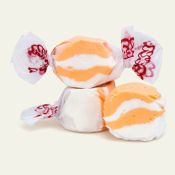 Three colorful wrapped Peaches and Cream saltwater taffy candies stacked together on a plain white background by Uranus Fudge Factory.