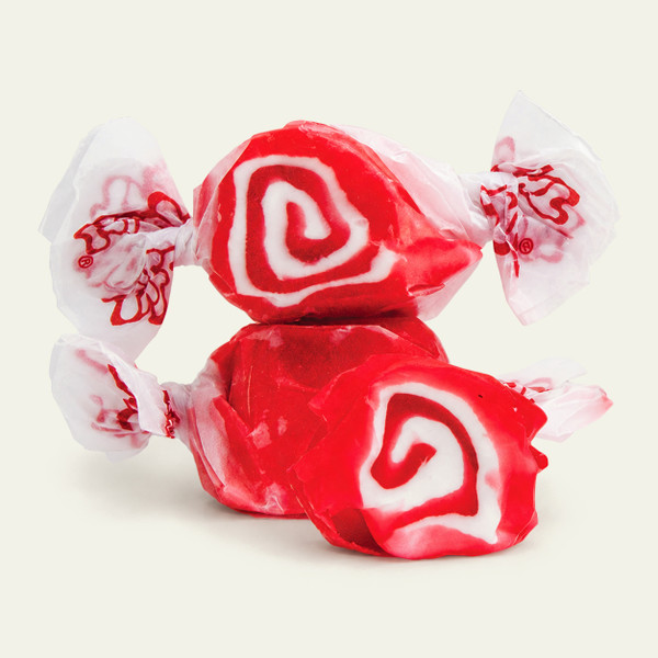  Three pieces of red salt water taffy candies with white swirls wrapped in wax paper.