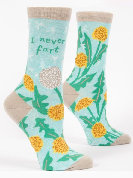 A pair of light aqua blue crew socks displayed against a plain white background. The socks feature tan accents on the toe, heel, and top cuff. They are decorated with a nature pattern of yellow dandelion flowers, jagged green leaves, and a white dandelion seed head with tiny seeds blowing away in the wind.