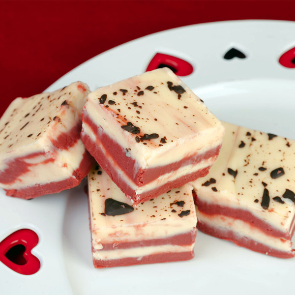 Red velvet fudge squares topped with chocolate flakes served on a heart cut plate from Uranus Fudge Factory.