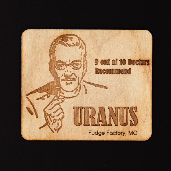 Square wooden magnet engraved with a retro doctor illustration and joke text from Uranus Fudge Factory.