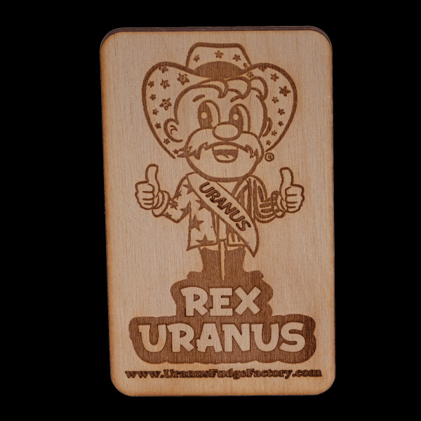 Rectangular wooden magnet engraved with the Rex Uranus mascot logo on black from Uranus Fudge Factory.