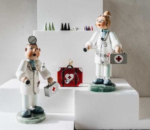 Two large incense smokers of a female and male doctor with a poetry in glass first aid suitcase ornament 