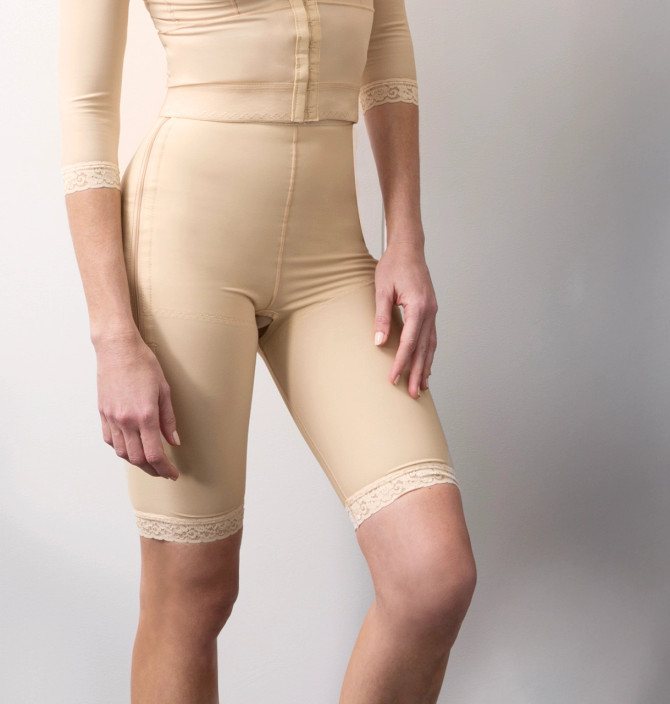 Low-waist mid-thigh compression girdle with dual padded side zippers for secure post-operative support.