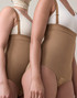 Close-up of Aesetica latte compression bodysuit showing high-waisted fit, adjustable suspenders and smooth abdominal support