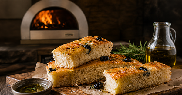 Wood-fired focaccia bread with rosemary, olives, and olive oil baked in an ilFornino wood-burning oven