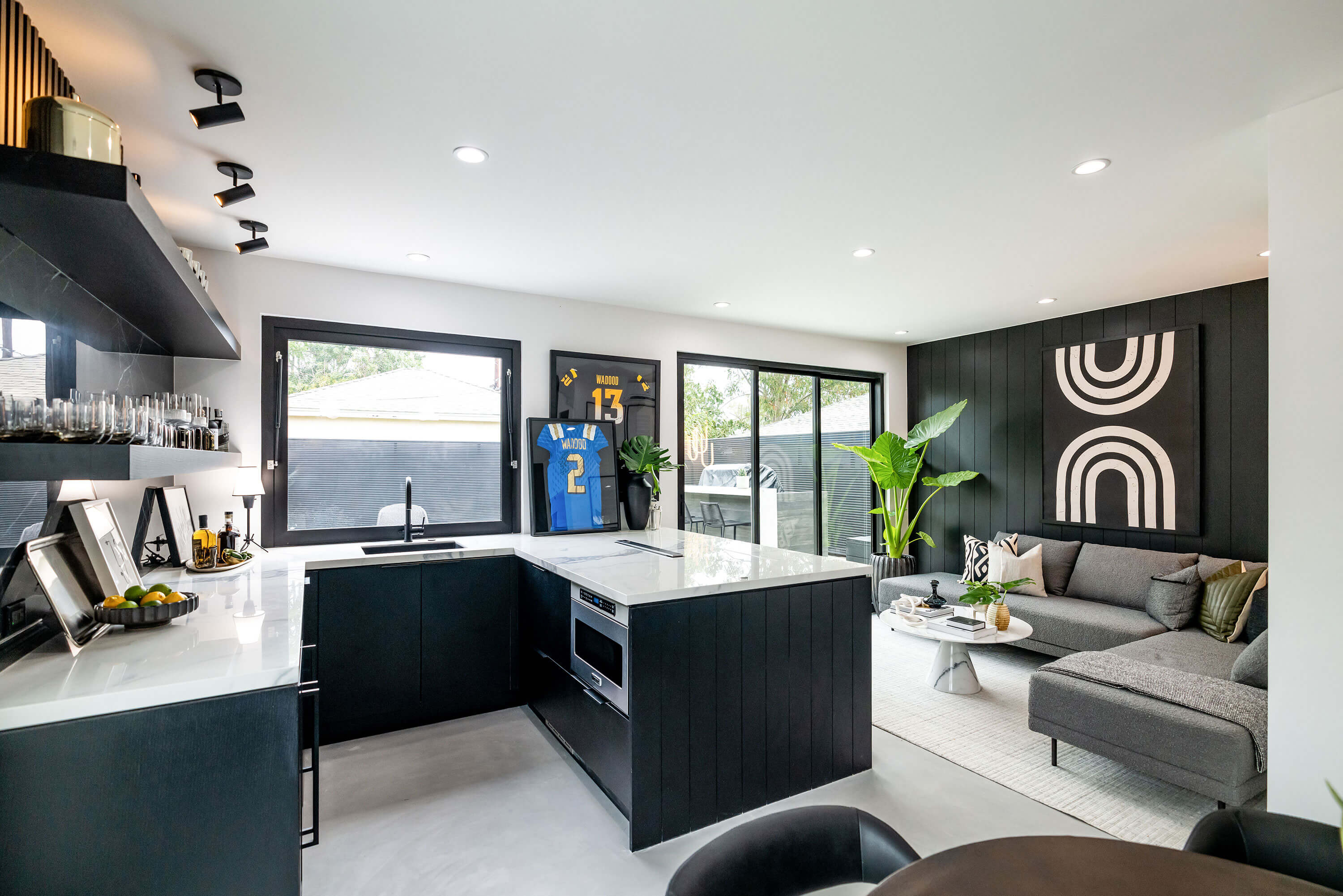 	Open-concept living room and kitchen with porcelain marble counters and modern furniture
