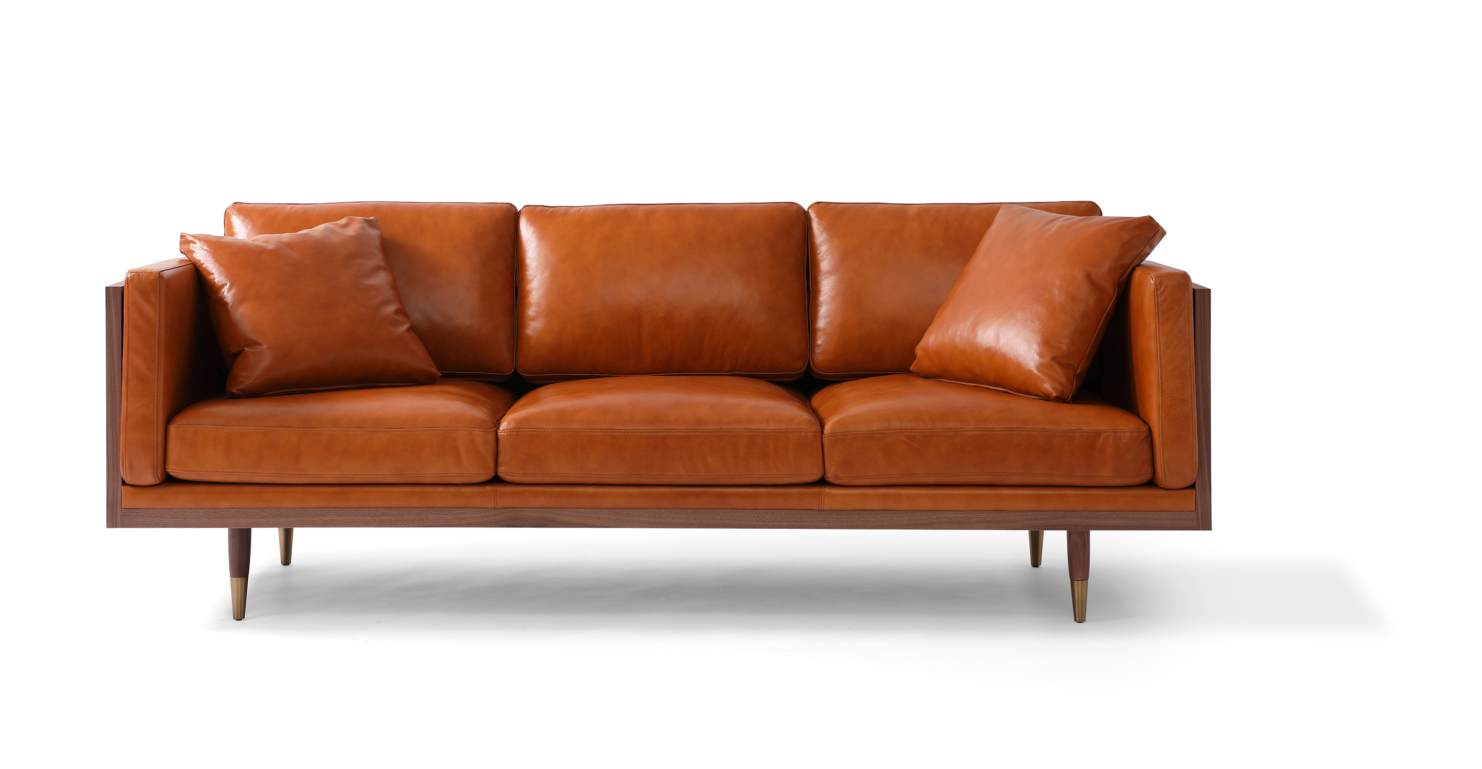 Woodrow Lush Tan leather is a walnut wood wrapped sofa. The top of the arms and back are all walnut wood rectangles, creating a box shape. The interior of the sofa back and seat are each three smooth removable cushions. The arms have rectangle cushions that slip between the exterior wall of the sofa and the seat cushion to create a tight and comfortable arm. The legs are matching walnut wood, tapered, and brass tipped.
