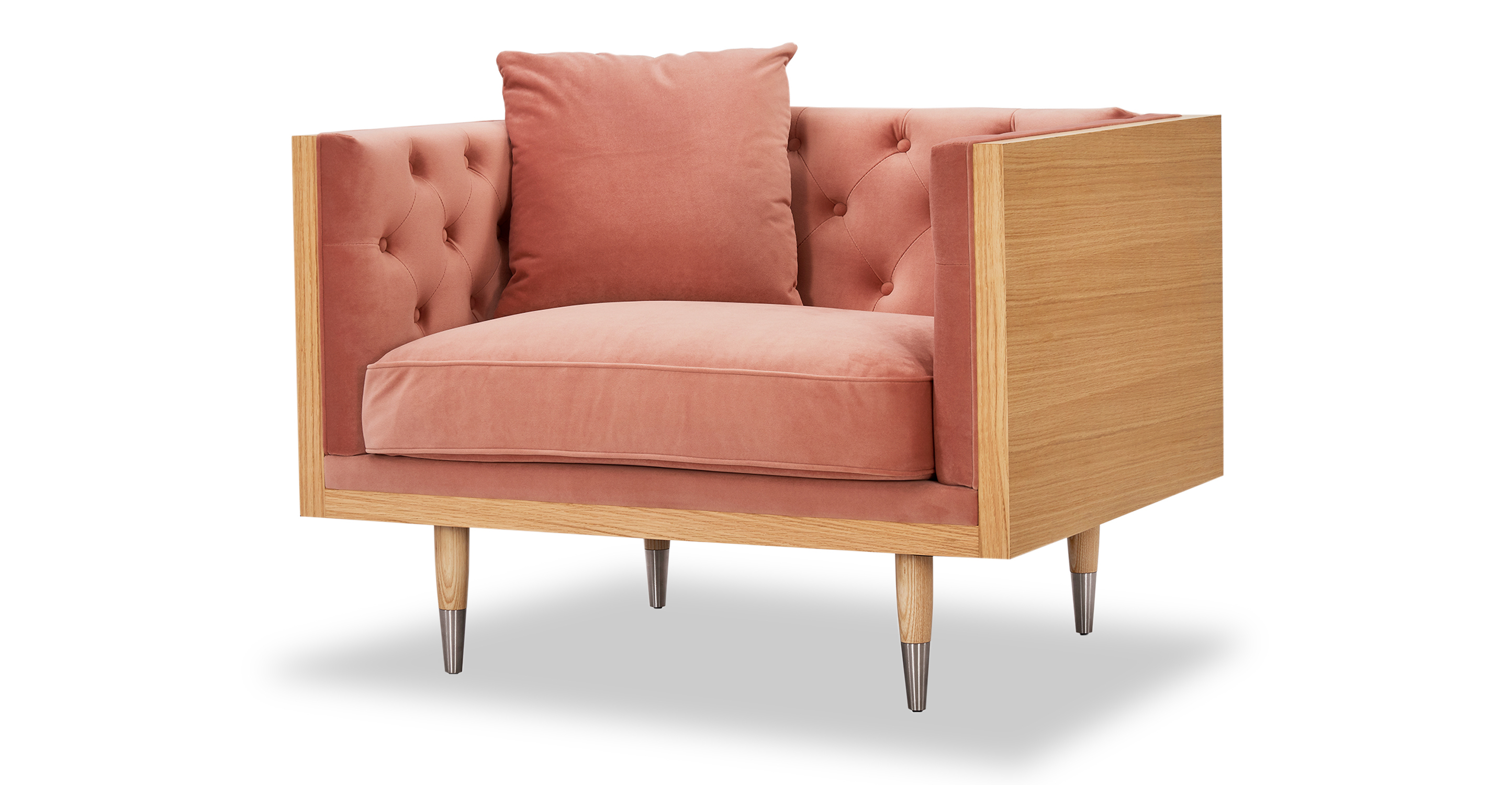 Woodrow Neo Blush velvet is a natural wood wrapped chair. The top and of the arms and back are all natural wood rectangles, creating a box shape. The interior of the chair back and seat are affixed and tufted cushions. There is a matching throw pillow. The seat cushion is smooth and removable. The legs are matching natural wood, tapered, and silver tipped.