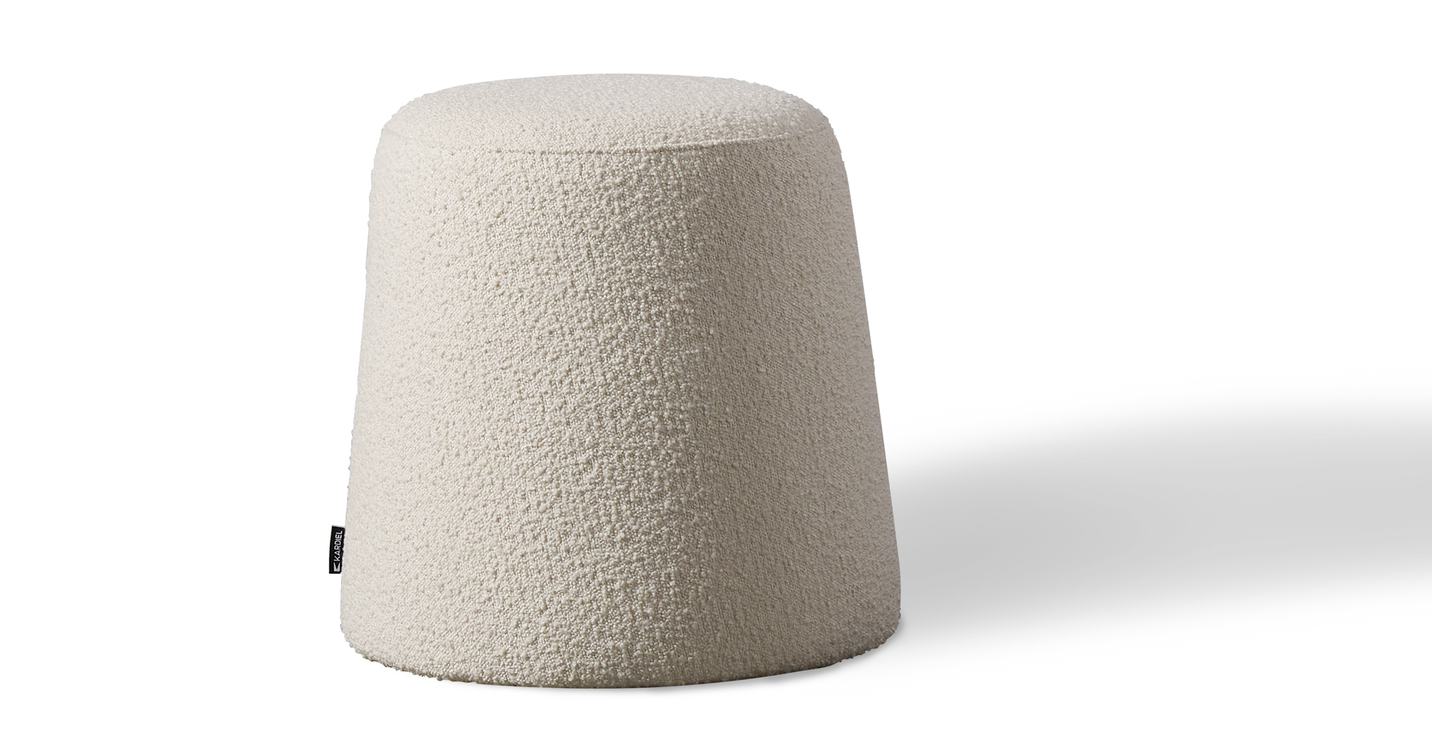 Thimble Cream Boucle is a sewing thimble shaped ottoman starts out wider at the bottom and slightly tapers to the flat top. The top of the 100% upholstered ottoman has a circle piping area to define the top. Because of the flat top, can be used with a tray as a table or extra seating. 