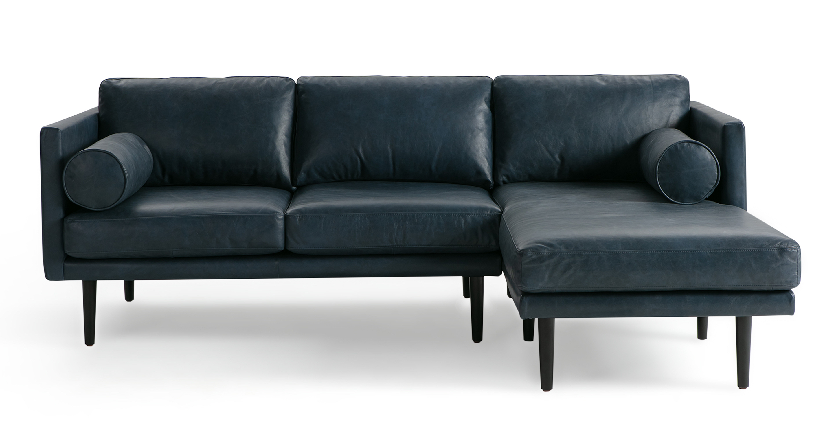 The Spectre Napoli Blue Leather Sectional is a timeless contemporary sofa that is 100% upholstered. It features a cohesive design with both the base frame and arms sharing the same thickness, resulting in a harmonious and consistent look. The sofa's portion has two seat and back cushions are removable and strike a balance between being well-cushioned and not overly stuffed. The chaise portion has one large seat cushion and one back cushion. To further enhance comfort, the Spectre includes two bolster pillows positioned on either side of the arm. The sofa is raised by tapered wooden legs.