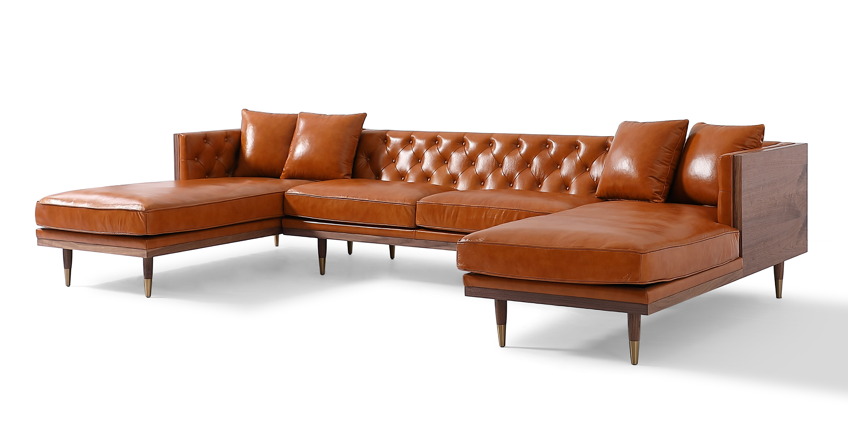 WoodNeoU Shaped Sectional in Tan leather has a walnut wood wrapped exterior. The sectional consists of one right chaise, one armless center love seat, and one left chaise piece. The exterior top of the arms and back are all walnut wood rectangles, creating a box shape. The interior of the sectional backs and arms are affixed and tufted cushions. The four seat cushions are smooth and removable. The legs are matching walnut wood, tapered, and brass tipped. The upholstery is tan in color. 