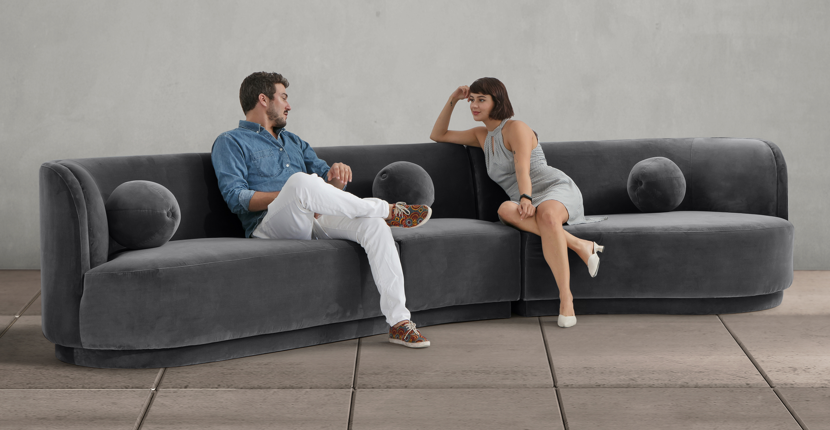 Room scene, showing two people sitting comfortably on the Moab East 3-pc sofa in gray Fossil velvet.