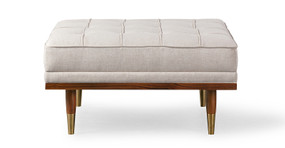 Image shows front facing picture of Mid-Century Modern Woodrow Box Ottoman in Viscose Woven Oatmeal Fabric. Frame and legs are walnut wood. Legs are brass tipped walnut wood. The cushion is button tufted.