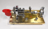 NOS Vibroplex Original Presentation gold base Morse bug, serial 105376, original Mobile AL box. Minor side corrosion from storage. Classic CW key, jeweled movement, red paddles. Ready for the collector or operator.