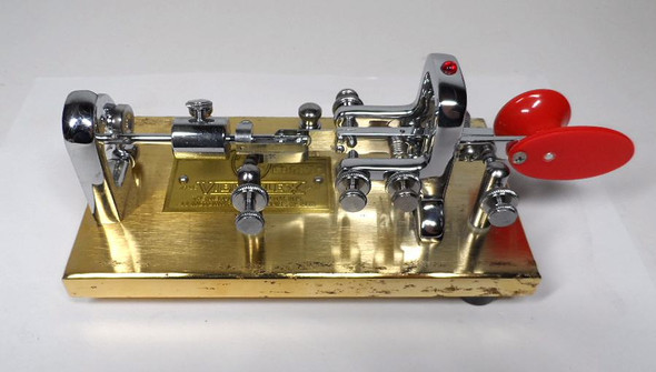 NOS Vibroplex Original Presentation gold base Morse bug, serial 105376, original Mobile AL box. Minor side corrosion from storage. Classic CW key, jeweled movement, red paddles. Ready for the collector or operator.