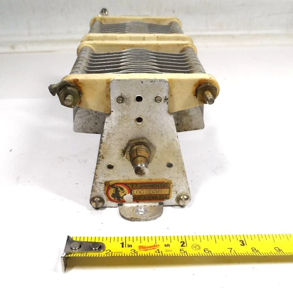 Genuine E.F. Johnson 100ED30 dual-section air variable capacitor. Each section 10-99 pF (approx. 14-105 pF measured), 0.075″ plate spacing, 2200 V peak rating. Compact Type E design with steatite insulation, aluminum plates, ¼″ shaft. Ideal for ham radio, antenna tuners, amplifiers, transmitters, and RF projects. Dimensions approx. 6⅝″ L × 2¾″ W × 2⅝″ H. Classic Waseca, MN quality. Clean used condition. Perfect for restoration or new builds needing reliable dual air variable capacitance.