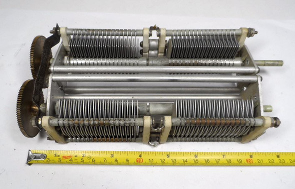 E.F. Johnson ganged air variable capacitor assembly. Consisting of two premium dual-section capacitors precision-synchronized via dual meshed brass gears, this unique configuration allows smooth 0 to 100% full-mesh rotation with a single 1/4-inch drive shaft. When wired together, the sections provide an expansive combined capacitance range from 57 pF minimum up to 830 pF maximum. Designed with an industrial-grade 1/16-inch plate spacing, it delivers a reliable 3,000V to 3,500V (3.5 kV) peak voltage rating. Measuring 9.5" L x 2" W x 4" H, this high-voltage tuning unit features rugged ceramic standoff insulators and a rigid frame, making it the perfect upgrade or replacement component for high-power linear amplifiers, broadcast transmitters, and custom antenna tuners.