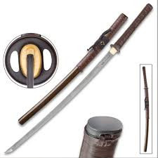 The Shikoto Rurousha Katana stands as a true testament to both innovation and tradition, bound in rustic genuine leather yet unbound by conventional design. At 41 1/4" overall, this full-sized katana boasts a 30" hand-forged, full-tang Damascus steel blade, featuring twin fullers and engraved kanji. Meticulously crafted by seasoned swordsmiths, the blade showcases thousands of layers of high carbon steel, forming mesmerizing patterns of waves, ripples, and swirls, making each Rurousha blade a unique masterpiece. Its elegant tsuka is wrapped in genuine leather thongs, providing both a distinctive visual appeal and a comfortable, no-slip grip, complemented by a flawlessly cast, minimalist tsuba with an antiqued patina. Encased in a hand-lacquered wooden saya with a handsome mottled color scheme and leather wrapping, the Rurousha katana is as functional as it is beautiful. Designed for the serious swordsman, it combines cutting-edge (pun intended) performance with historical craftsmanship. Each blade is forged with a painstaking level of detail, ensuring unparalleled sharpness, strength, and balance. Whether you wield it in combat or display it with pride, the Rurousha katana is heirloom-quality, destined to be passed down for generations.