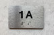 APT NUMBER 1A COMPLIANCE SIGN-UNIT NUMBER COMPLIANCE SIGN WITH RAISED LETTERS