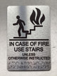 NYC IN CASE OF FIRE USE STAIRS UNLESS OTHERWISE INSTRUCTED COMPLIANCE SIGN WITH RAISED LETTERS COMPLIANCE SIGN