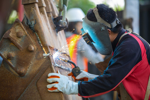 man welding with face protection