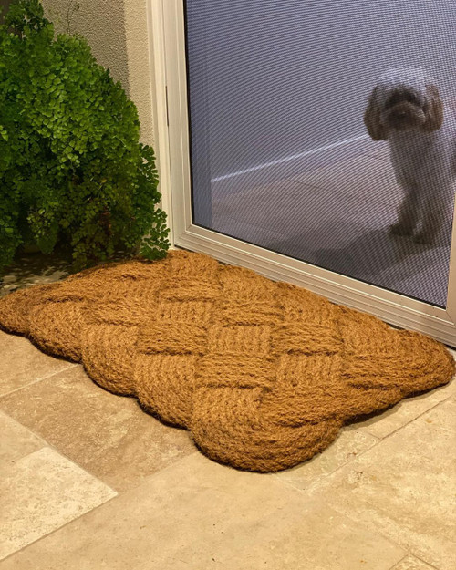 Photo of love knot door mat at front door with puppy