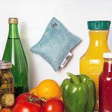 Moso Bag hanging in a fridge near produce. More powerful than baking soda. Lasts up to 2 years