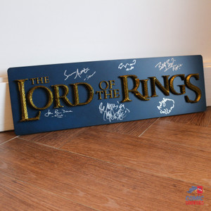 Signed Lord of the Rings plaque featuring autographs from all four Hobbit actors, Gimli, and Gollum. Includes 3D raised lettering inspired by the film’s title design.