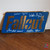 Fallout signed plaque featuring autographs from Ella Purnell, Aaron Moten, Walton Goggins, and Kyle MacLachlan. Flat brushed-brass style collectible inspired by the Fallout series.