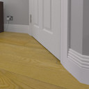 Skirting World Cloud MDF Skirting Board, white decorative skirting board installed at the base of the wall next to a door and wooden floor.