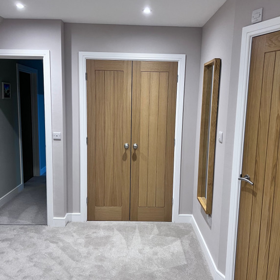 Skirting World Grooved 1 Chamfered MDF Architrave, installed around door frames and walls, in a modern interior setting.