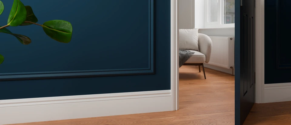White 330 skirting boards and matching architrave with navy Florence panel mouldings beside an open doorway.